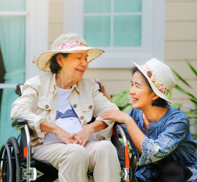 caregiver attending to an elderly woman on wheelchair