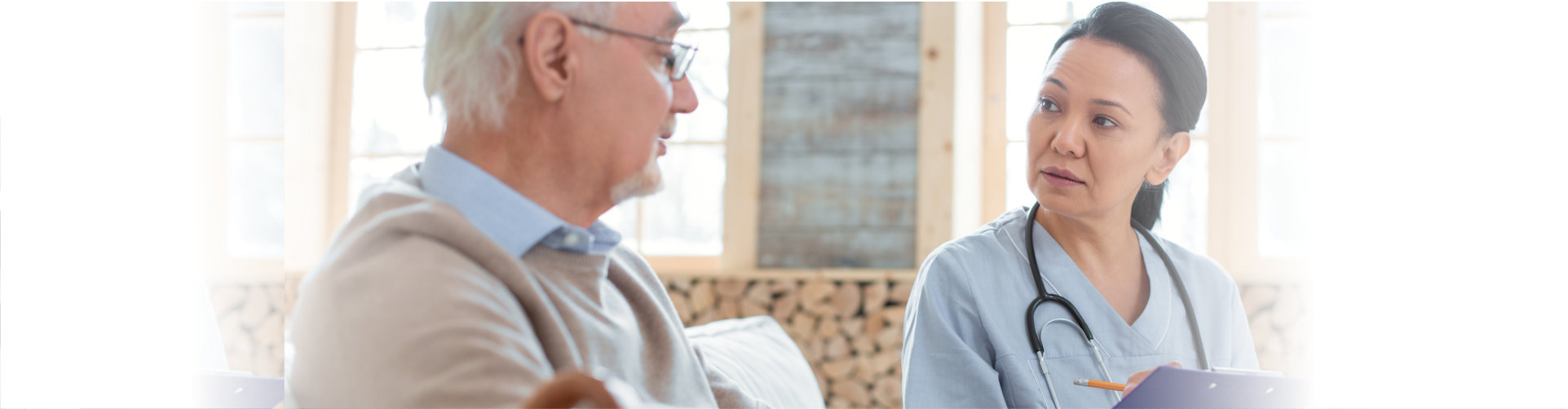 concentrated doctor holding clipboard while taking notes and communicating with senior man