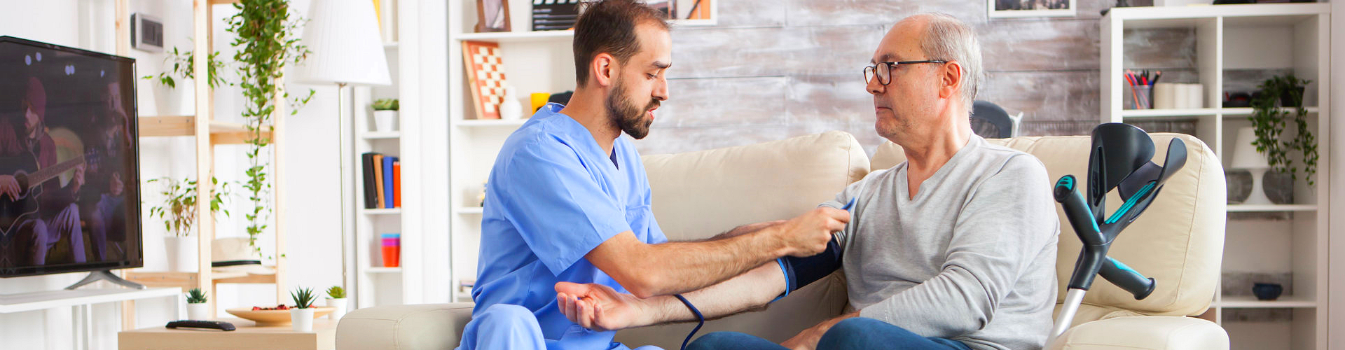 caregiver checking blood pressure level of elderly man